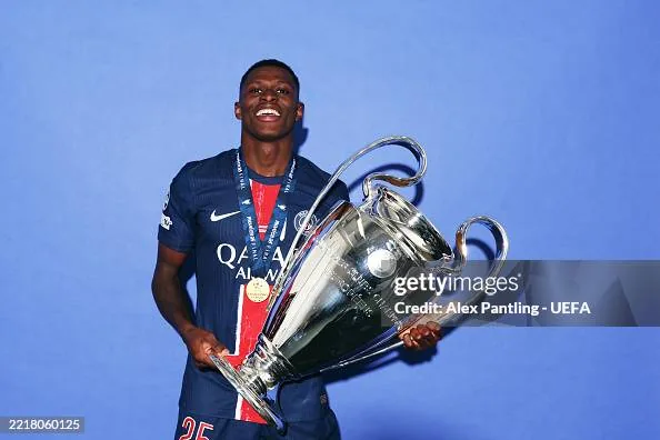 Nuno Mendes holding the UEFA Champions League trophy